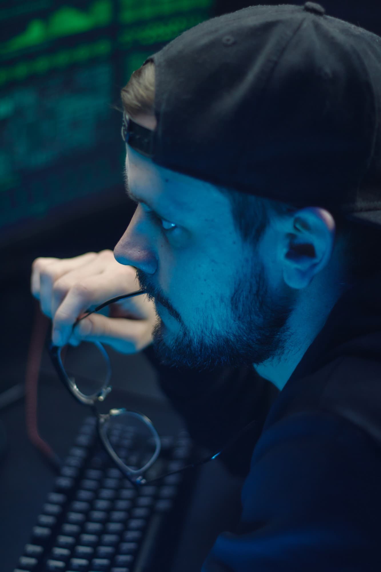 An engineer studying a monitor, lit by screen light