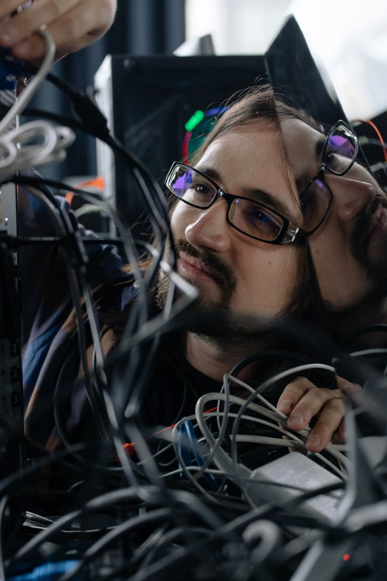 A technician working through a bundle of network cables